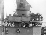 Burke reading on the starboard bridge wing of his flagship, USS Charles Ausburne, Solomon Islands, 1943-1944