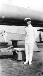 Ensign Burke posing by the 14-inch guns of USS Arizona, 1923