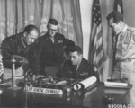 Claire Chennault at his desk with other officers, 1940s