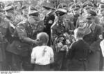 German children presenting flowers to SS-Gruppenführer Wilhelm Koppe, SS chief Heinrich Himmler, and Gauleiter of Oberschlesien (Upper Silesia) Fritz Bracht, date unknown