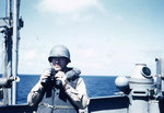 Lieutenant Howard W. Whalen holding binoculars aboard USS Sanborn, 1945, photo 1 of 2
