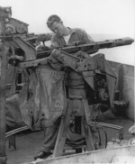 Seaman 1st Class Frank Stanley cleaning a 20mm gun aboard USS Anzio, 19 Apr 1945