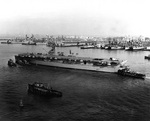 French aircraft carrier Bois Belleau moving to Norfolk Naval Base, Virginia, United States for aircraft loading, Dec 1953; note New Jersey, Albany, and Casa Grande in background