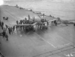 Crewmen aboard HMS Formidable pushing a damaged Corsair fighter which had just landed, off Norway, Aug 1944. Note the prop with one blade badly bent.