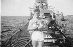 Chief Motor Machinist Mate Jim Ellis holding two puppies aboard USS Gar, date unknown