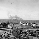 Intrepid smoking after being hit by Japanese special attack aircraft, seen from battleship New Jersey, 25 Nov 1944; note New Jersey