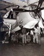 Ordinancemen loading a 1,000-pound bomb into the bombay of a TBM-1C aboard USS Intrepid, 1943-1945; note flame arrester on the plane