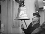 Soviet sailor sounding the bell aboard HMS Royal Sovereign, Scapa Flow, Scotland, United Kingdom, 30 May 1944