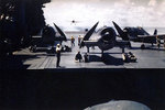 F6F-3 Hellcat fighters on the flight deck of Saratoga as a TBM Avenger approached to land, circa 1943-44