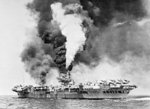 HMS Victorious on fire after being struck by Japanese special attack aircraft, off Sakishima Gunto (Islands), Japan, 9 May 1945