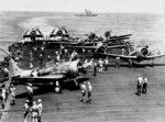 SBD-3 Dauntless, F4F-4 Wildcat, and TBF-1 Avenger aircraft aboard USS Enterprise, northeast of Nouméa, New Caledonia, 2 May 1943; note USS Washington in background