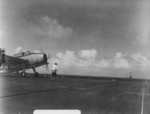 Flight deck crew chief giving taxiing instructions to a just-landed TBM-1C Avenger of Torpedo Squadron 81 aboard USS Wasp, 23 Dec 1944; the aircraft had just returned from searching for Typhoon Cobra survivors