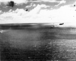 Zuikaku settling as she sinks, 25 Oct 1944; profile of an Avenger is seen flying overhead