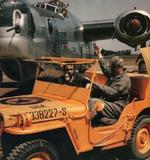 Brightly painted Willys MB Jeep leading B-24J aircraft at an unknown USAAF Air Field; note the special orange paint within National Insignia on hood, which changed colors when exposed to nerve agents