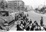 Polish civilians filing through a street in Warsaw, Poland, Aug 1944, photo 1 of 2; note Marder II tank destroyer on left
