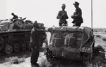 General Ulrich Kleemann of German 90th Light Africa Division speaking to a photographer aboard his SdKfz. 250 half-track command vehicle, North Africa, 1942; note StuG III in background