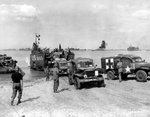 LCT-550 landing Dodge WC54 field ambulances of the 546th Medical Company at Normandy, France, Jun 12, 1944; note snorkel tube for fording streams on lead ambulance.