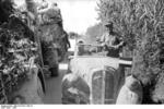 Skoda automobile with officers on board pulling aside to let a halftrack vehicle towing a 8.8 cm FlaK gun pass, Rimini-Ancona, Italy, 1944