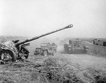 A Cromwell tank and jeep of 10 PSK, Polish 1st Armored Division passing an abandoned German PaK 43/41 gun during Operation Totalize, France, 8 Aug 1944