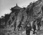 Japanese troops scaling a wall, China, late 1937 to early 1938