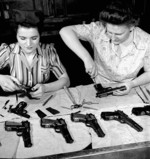 Agnes Apostle and Joyce Horne working on the final assembly of Browning Hi-Power handguns at the Inglis factory in Toronto, Ontario, Canada, Apr 1944