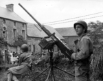 American soldiers with Browning M2HB machine gun in a town in Normandy, France, 1944