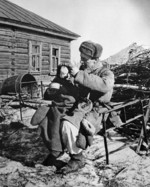 Soviet soldier taking care of a war orphan, Russia, 1943; note PPSh-41 submachine gun in soldier