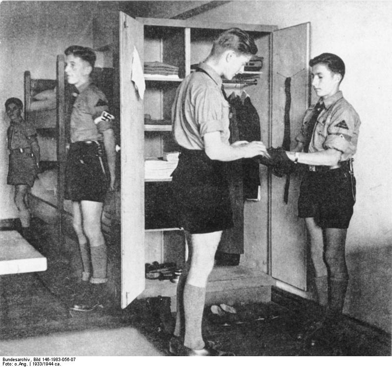 Hitler Youth leader inspecting the locker of other members, date unknown