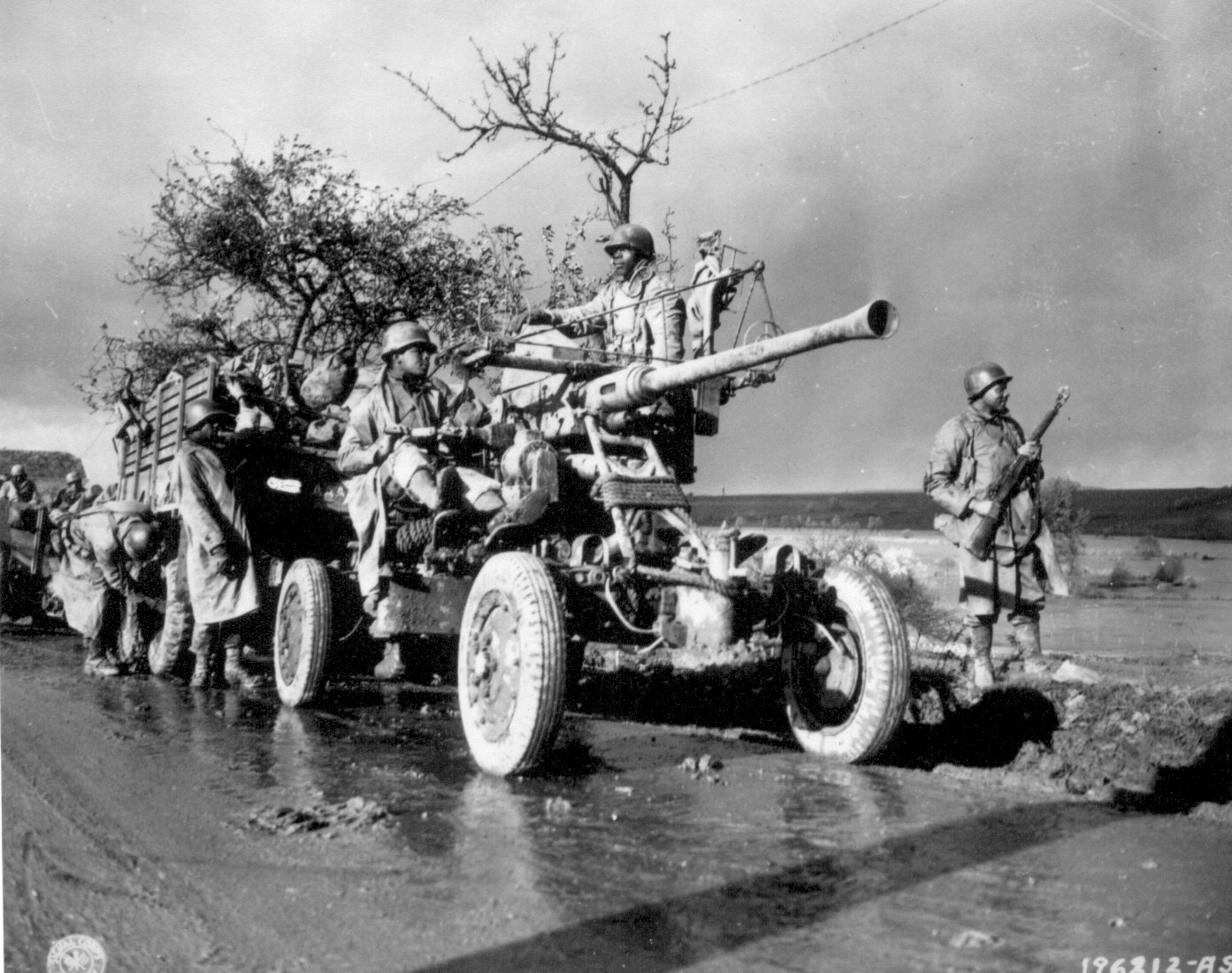 African-American soldiers of Battery A, 4520th Anti-Aircraft stood by and checked their equipment while the convoy took a break, 9 Nov 1944