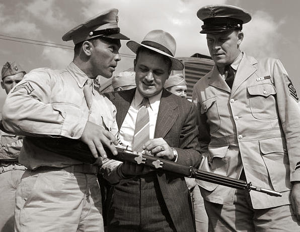 US Army Sergeant Vineyard showing his rifle to civilian welder George Woolslayer and US Navy enlisted man John Evans at Allegheny-Ludlum Steel, Pittsburgh, Pennsylvania, United States, Aug 1942