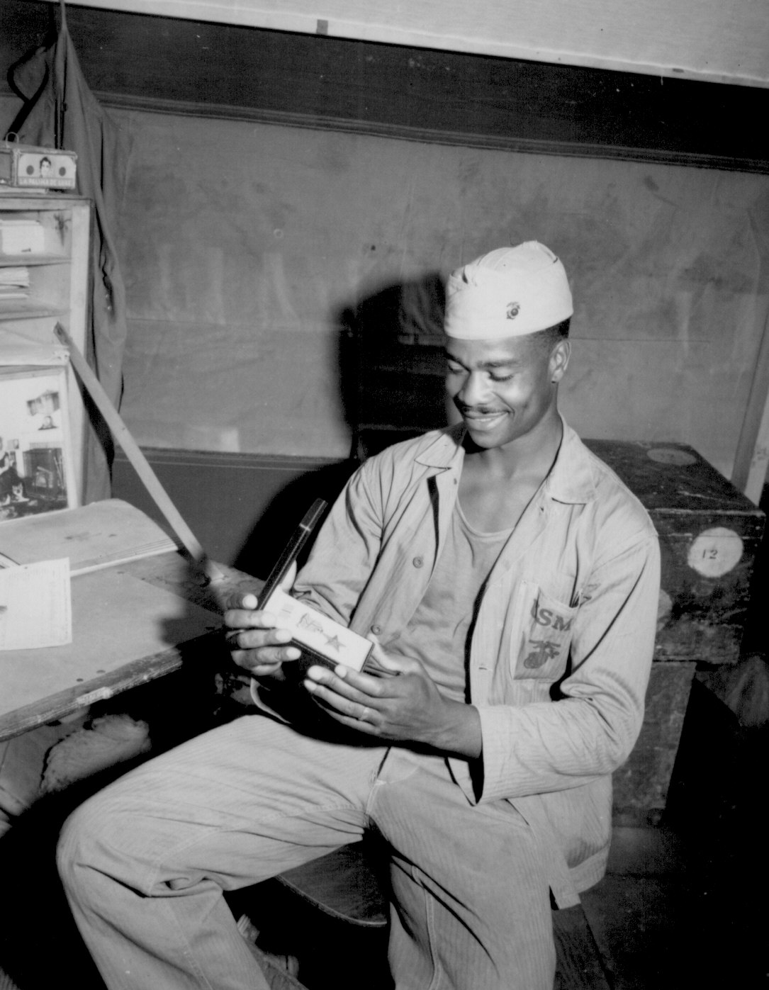 African-American US Marine 4th Ammunition Company Private First Class Luther Woodward admiring his Bronze Star medal, 17 Apr 1945; his award was later upgraded to the Silver Star