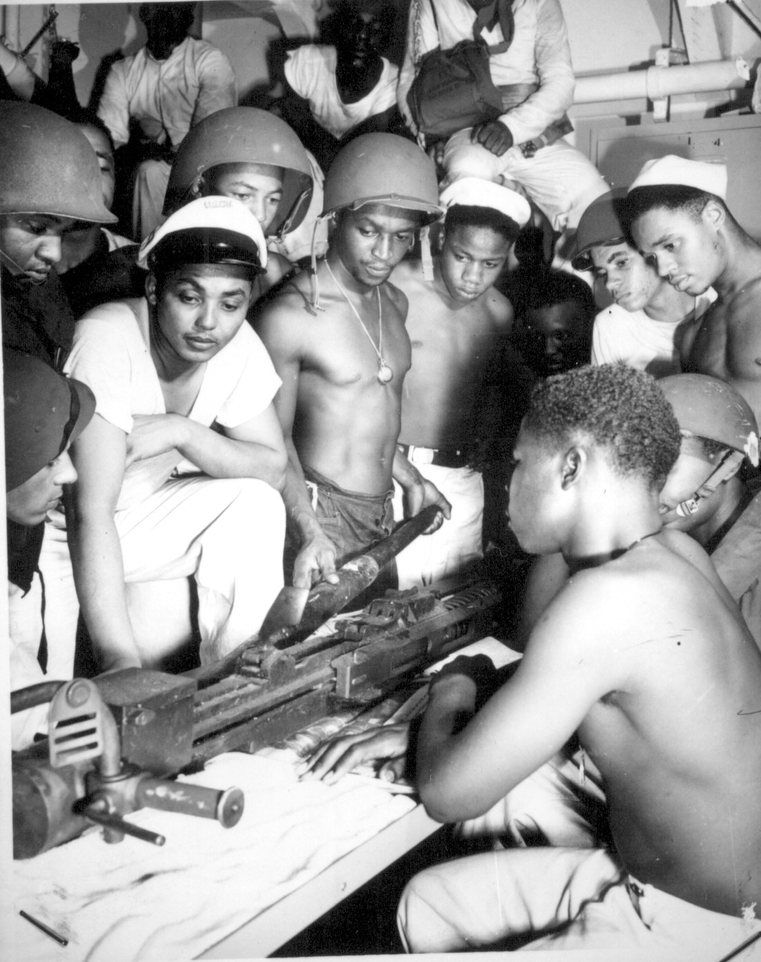 African-American US Coast Guardsmen studying the assembly of a 20-mm AA gun aboard a ship, date unknown