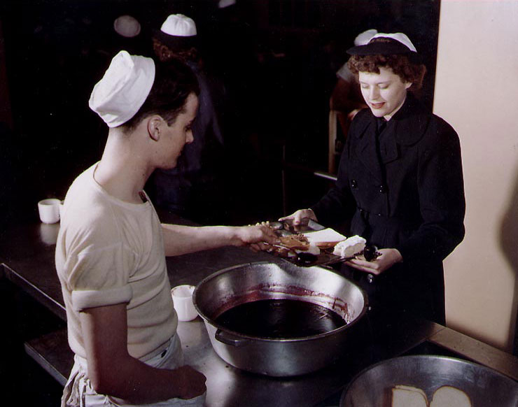 WAVES Seaman 2nd Class Verona Livingston received desert from Cook 2nd Class William Barry during 'chow' time, Naval Air Station, Norfolk, Virginia, United States, during WW2