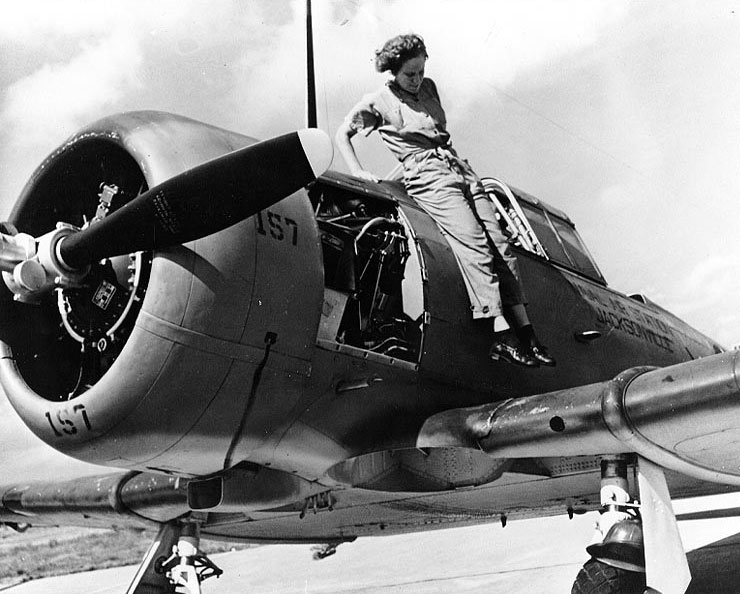 WAVES Aviation Machinist's Mate Mary Arnold jumping down from the fuselage of a SNJ training aircraft, Naval Air Station, Jacksonville, Florida, United States, 4 Nov 1943