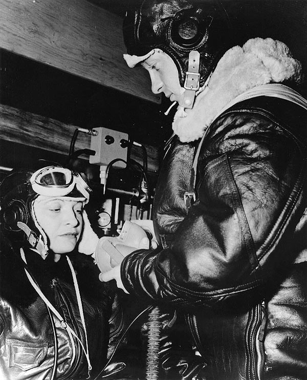 US Navy sailor helping a WAVES trainee pilot putting on her oxygen mask,  Naval Air Station, Jacksonville, Florida, United States, 15 Oct 1943