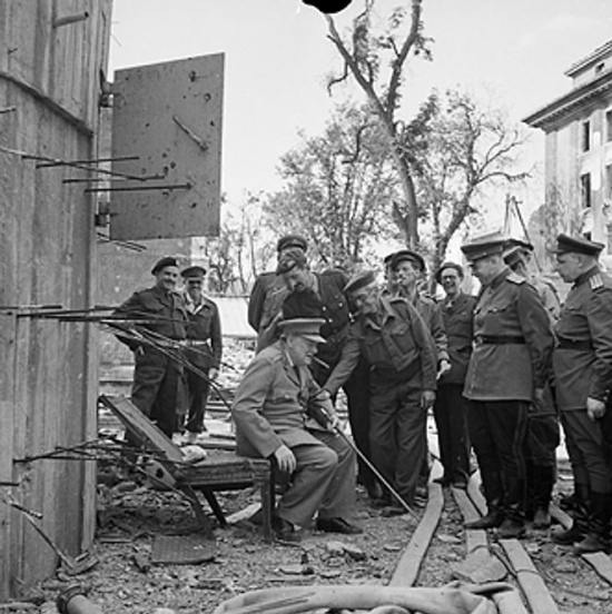 Churchill sitting in a damaged chair taken out from Hitler's bunker in Berlin, Germany, 16 Jul 1945