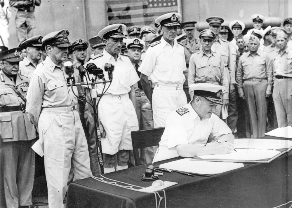 Admiral Sir Bruce Fraser signing the surrender instrument on behalf of the United Kingdom aboard USS Missouri, Tokyo Bay, Japan, 2 Sep 1945, photo 1 of 3