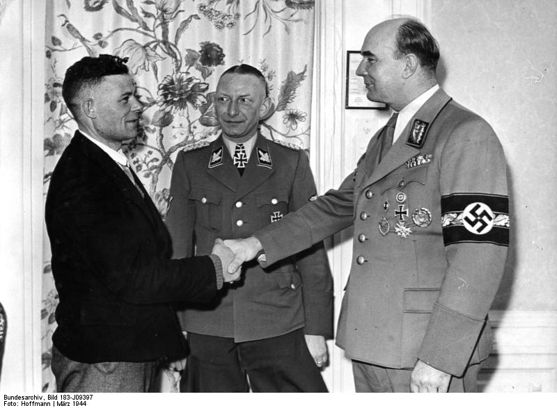 Greiser shaking hands with the one millionth German resettler of Wartheland, Posen, Germany, 16 Mar 1944