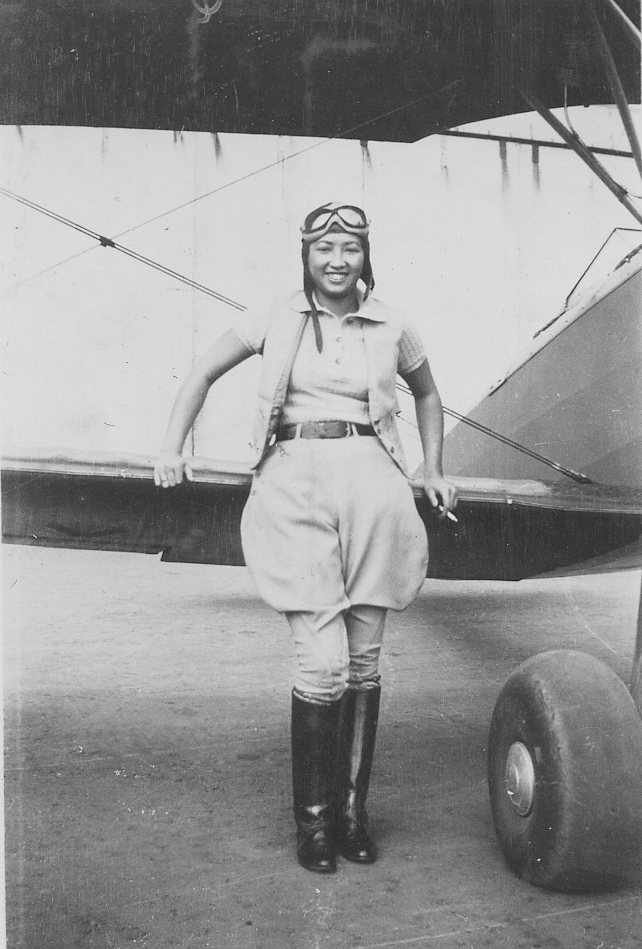 Hazel Lee posing with a biplane, circa 1930s