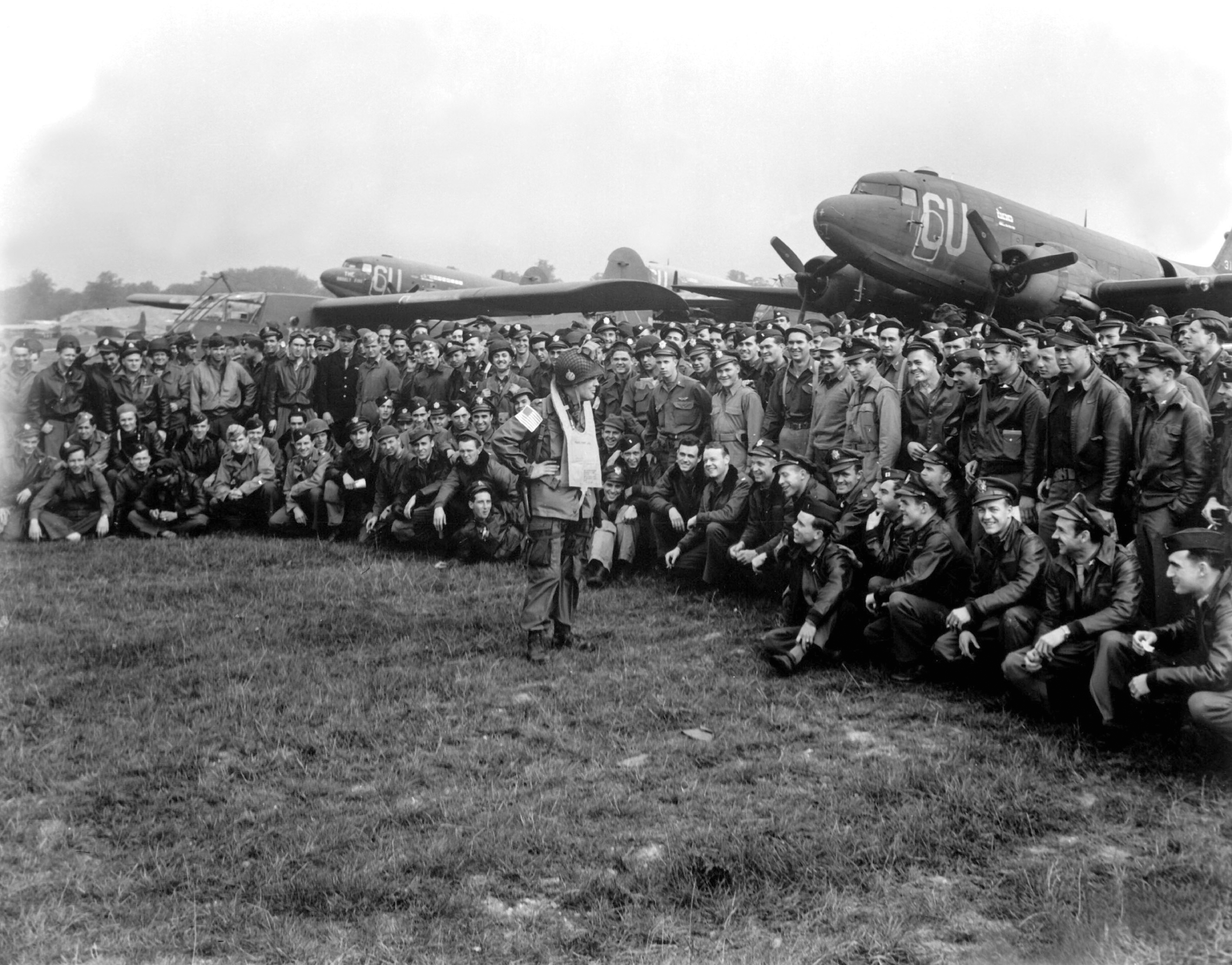 US Army Brigadier General Anthony C. McAuliffe speaking to his glider pilots, England, United Kingdom, 18 Sep 1944; note C-47 Skytrain and CG-4A glider aircraft in background