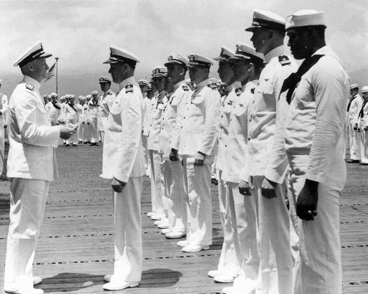 Clarence McClusky receiving the Distinguished Flying Cross award from Admiral Chester Nimitz, onboard carrier Enterprise, Pearl Harbor, US Territory of Hawaii, 27 May 1942; note Doris Miller in foregr
