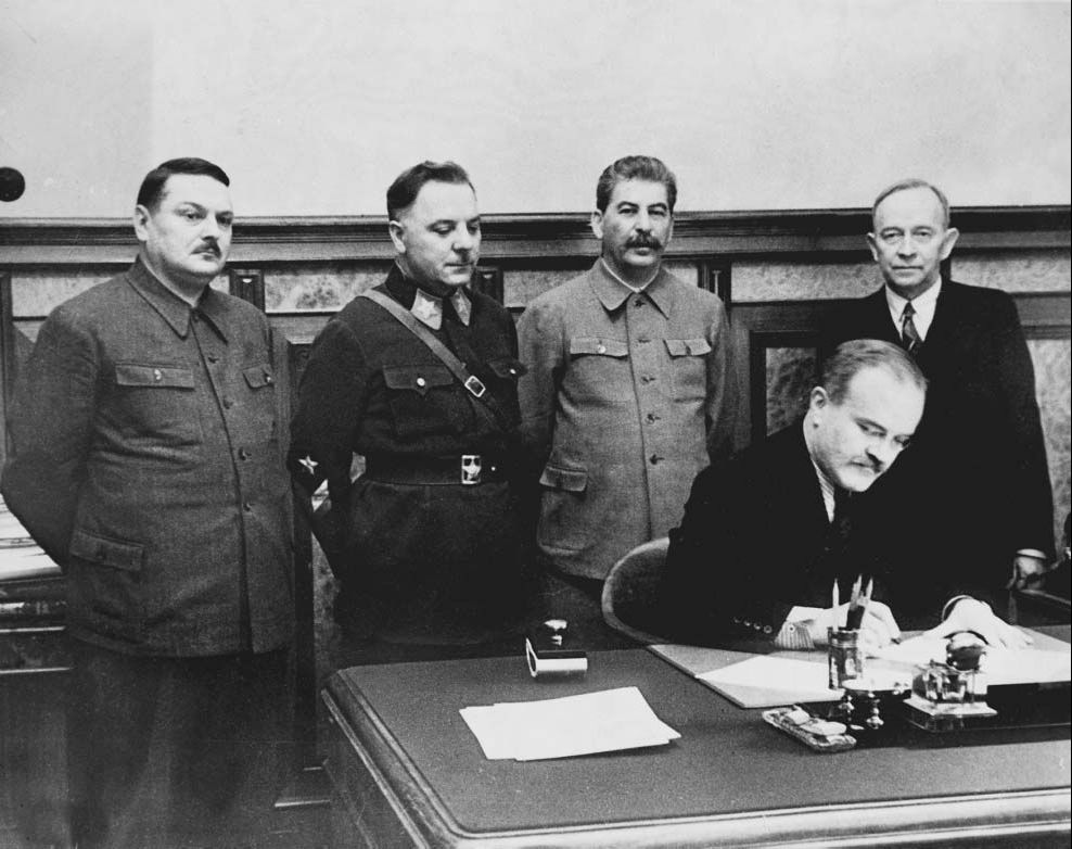 Vyacheslav Molotov signing a pact with Soviet-puppet state Finnish Democratic Republic, Moscow, Russia, 2 Dec 1939; Andrei Zhdanov, Kliment Voroshilov, Joseph Stalin, and Otoo Wille Kuusinen in background