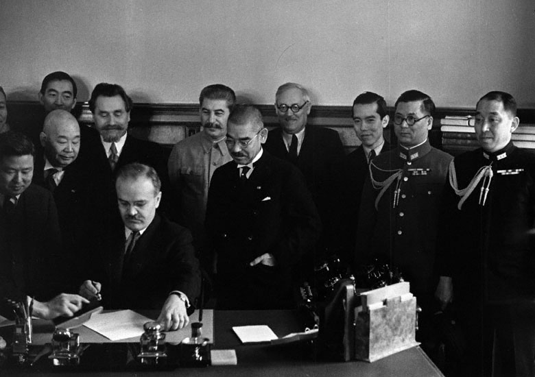 Soviet Foreign Minister Molotov signing the Soviet-Japanese Neutrality Pact, 13 Apr 1941; note Matsuoka and Stalin in background