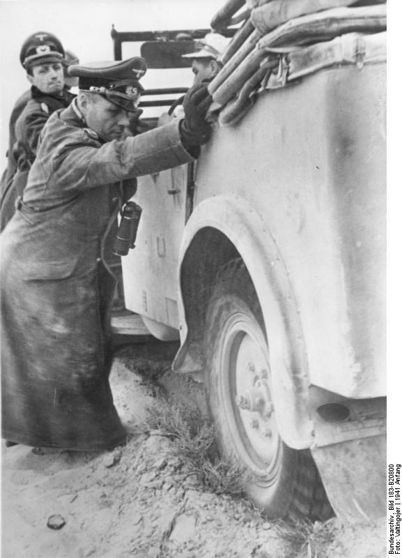 Colonel General Erwin Rommel and General Siegfried Westphal helping with pushing a stuck vehicle, North Africa, early 1941