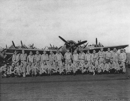 Group portrait of airmen with a FM-1 Wildcat fighter aboard USS Coral Sea, 30 Oct 1943