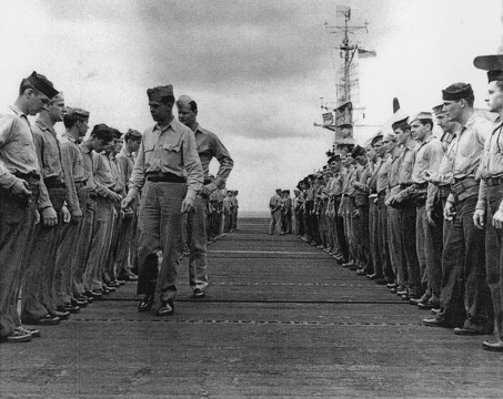 Ensign Richard Hansen (with Division Chief Kenneth Firestone) inspecting sailors aboard USS Anzio, 28 Apr 1945