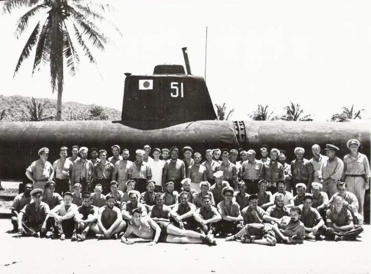 Officers and men of USS Dragonet posing before a Japanese submarine at Camp Dealy, Guam, Mariana Islands, mid- to late- Jun 1945