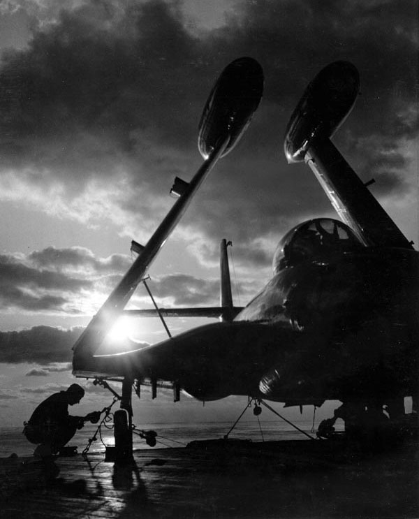 An airman of Essex lashed a F2H Banshee fighter to the flight deck, off Korea, 8 Mar 1952