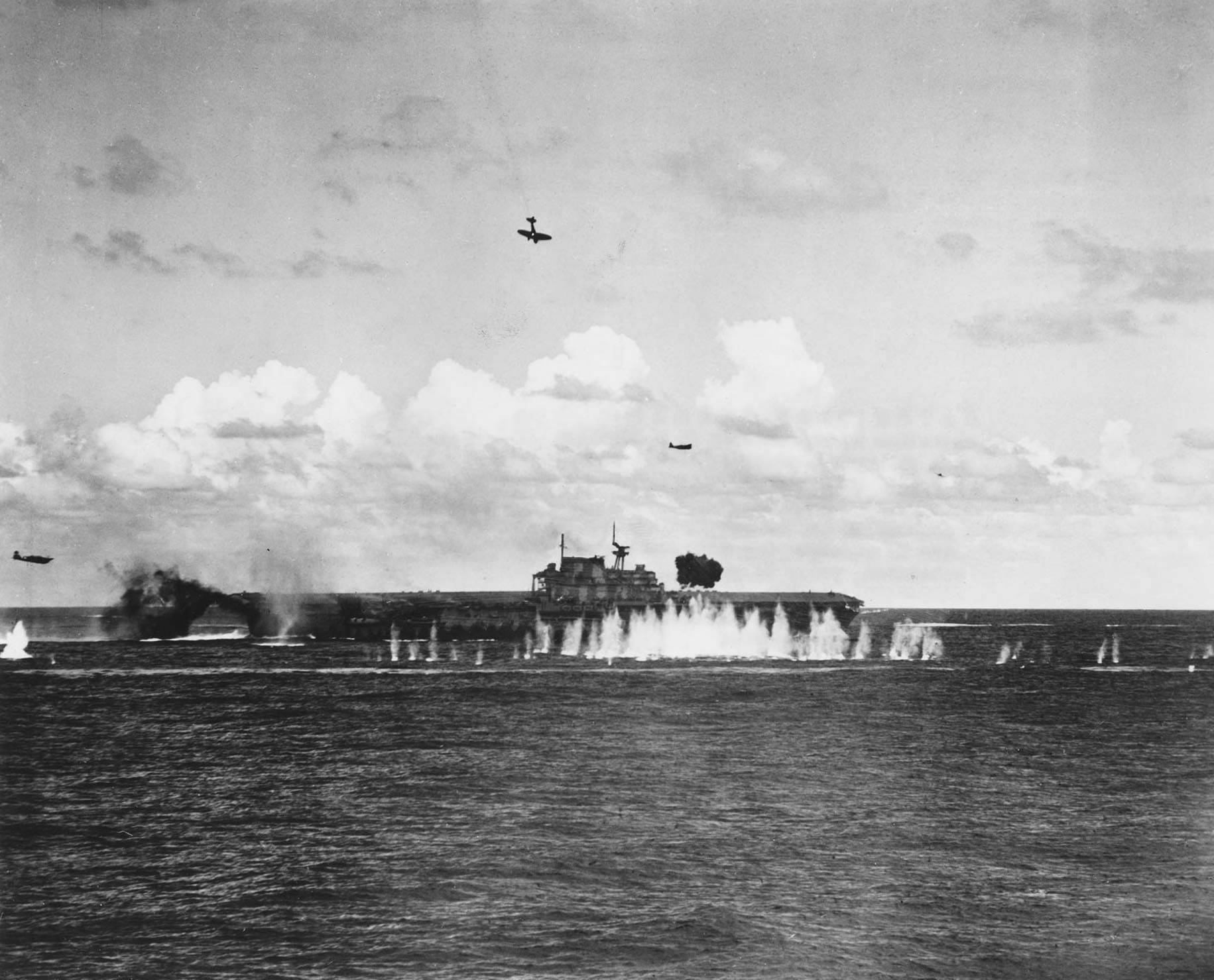 Japanese pilot Shigeyuki Sato in a D3A dive bomber plunging toward USS Hornet during Battle of the Santa Cruz Islands, 26 Oct 1942; note B5N torpedo bomber in level flight and splash from anti-aircraft shell burst in front of Hornet