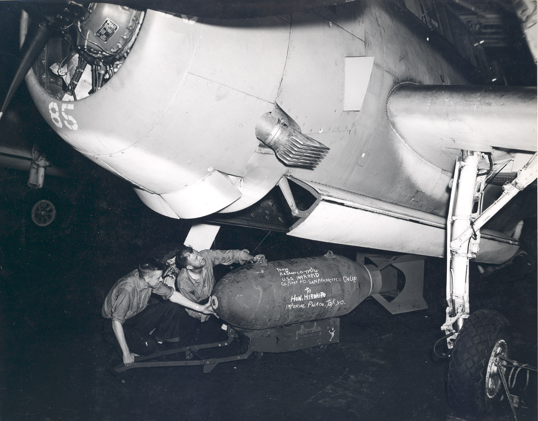 Ordinancemen loading a 1,000-pound bomb into the bombay of a TBM-1C aboard USS Intrepid, 1943-1945; note flame arrester on the plane’s exhaust port